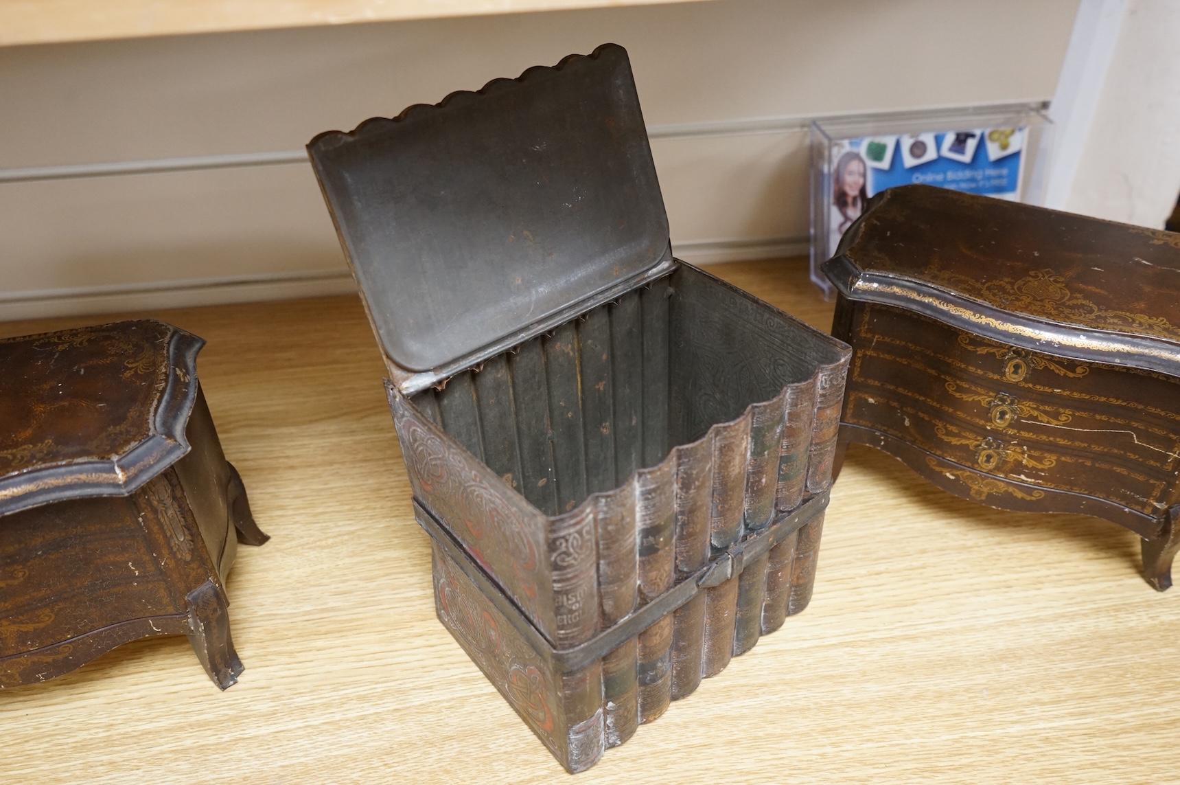 A Huntley and Palmer biscuit tin, modelled as a set of books and and two Mcvitie and Price tins modelled as French chests, tallest 16cm